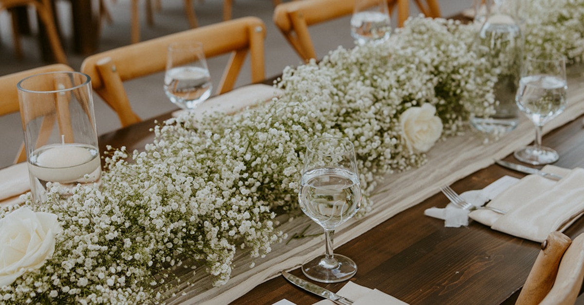 Elegant reception table with floral arrangements and place settings included in all inclusive wedding services