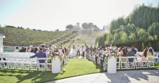Outdoor wedding ceremony overlooking rolling vineyards at Léal Vineyards, a premier vineyard wedding venue in California