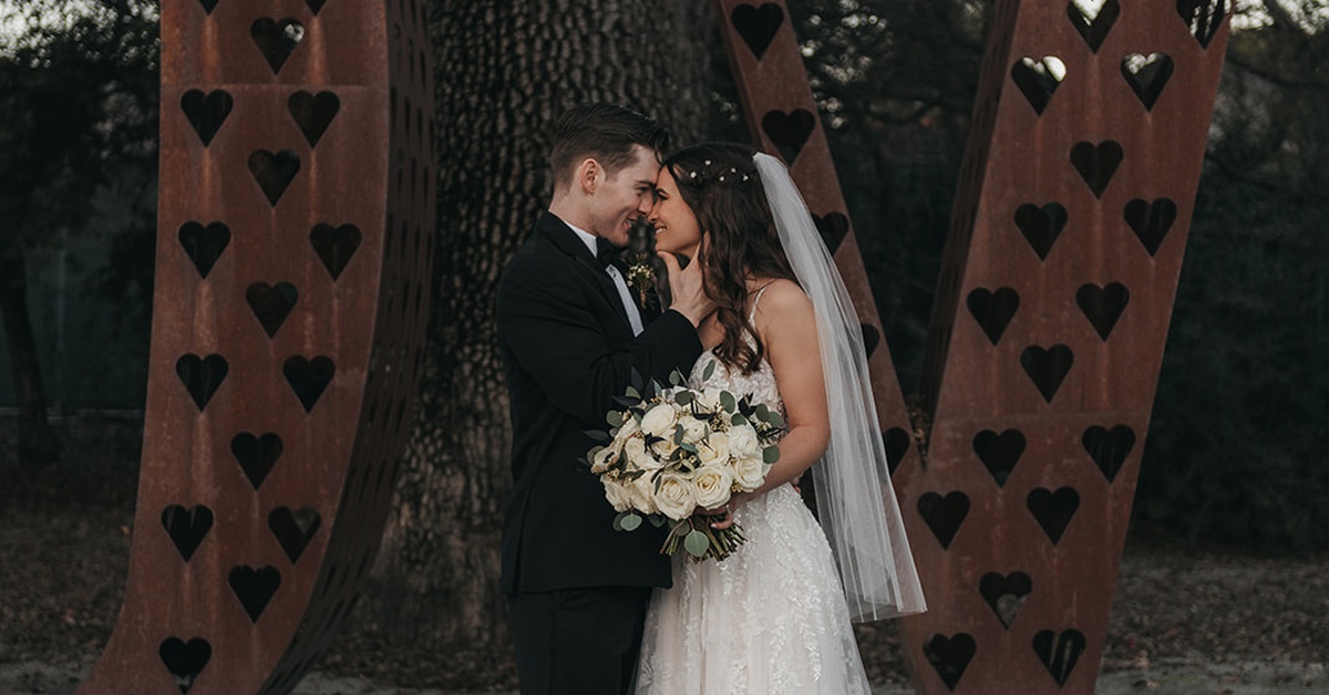 Romantic wedding portrait in front of LOVE sculpture at vineyard wedding venue near Morgan Hill
