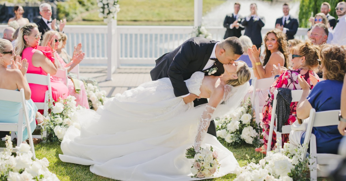 Outdoor wedding ceremony with couple kissing and guests applauding at a wedding venue in Hollister CA