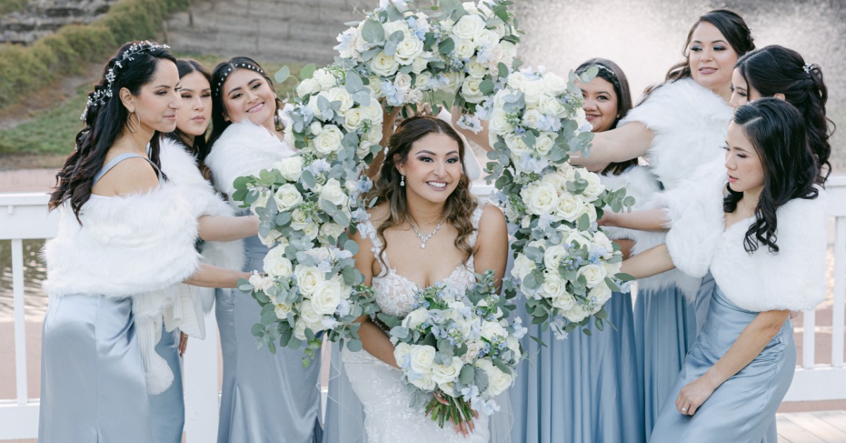 Bride and bridesmaids with floral arrangements at a California vineyard wedding in spring