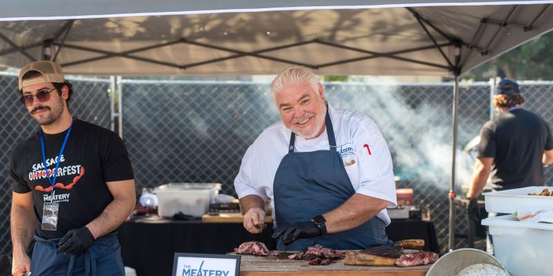 Chef Todd Fisher holding meat at MOHI Food and Wine festival