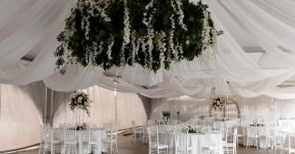 Elegant wedding reception setup with draped ceiling and chandelier at an event venue in California